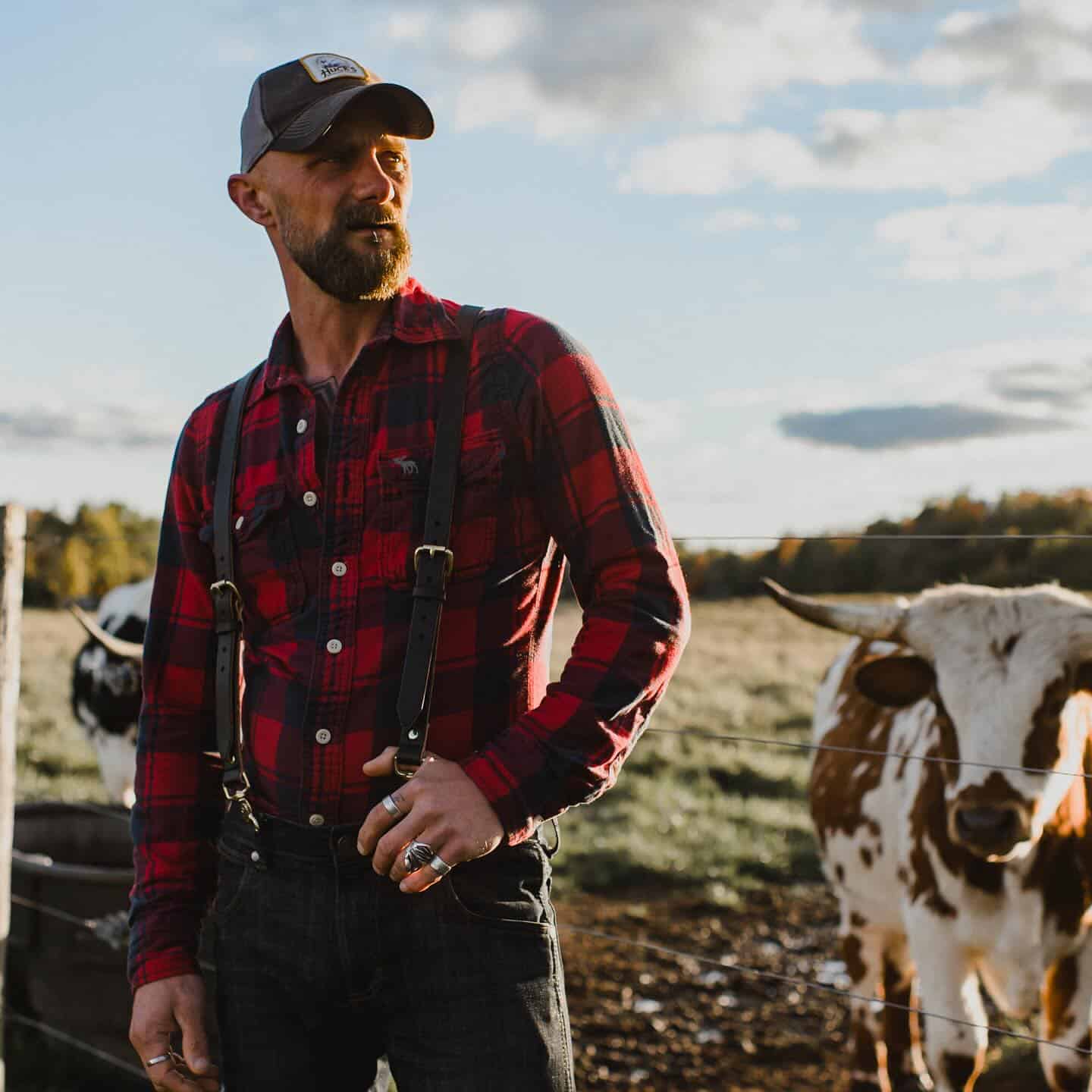 man in a red checked shirt and black jeans with suspenders