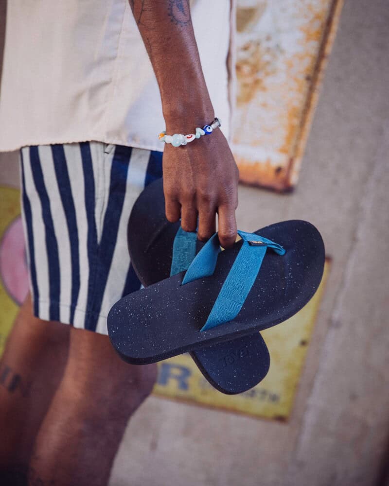 man holding a pair of teva flip flops