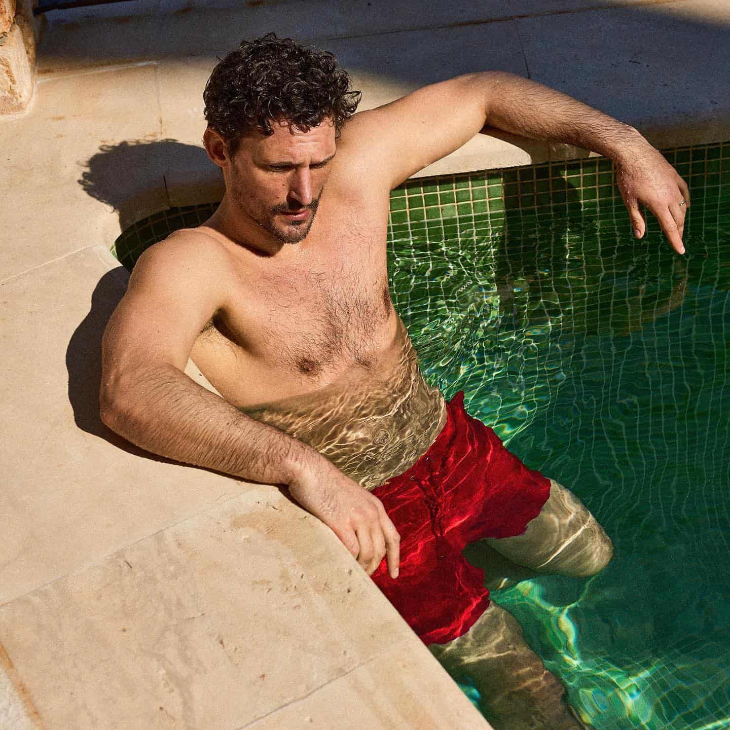 man in the pool wearing red drawstring shorts