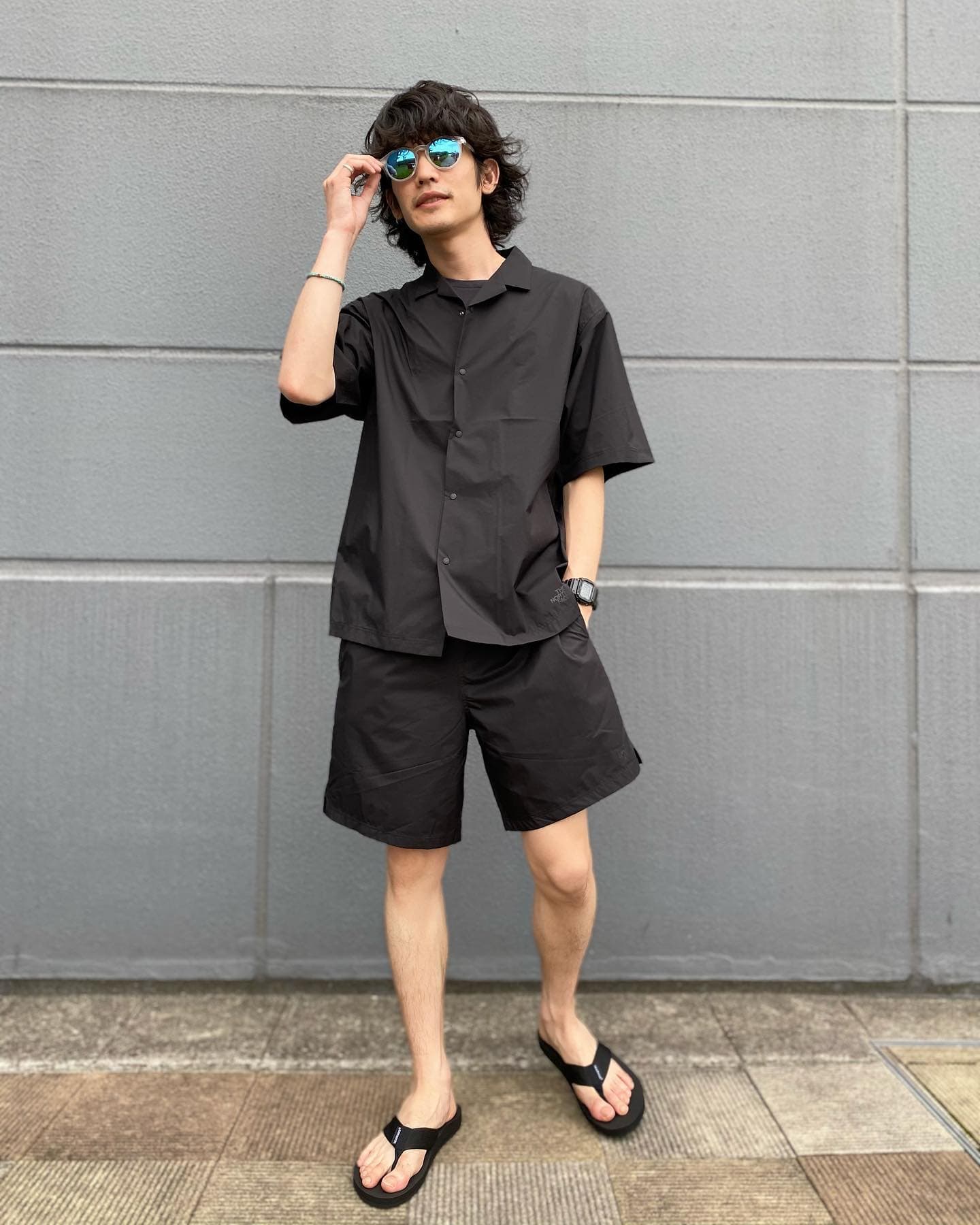 man with sunglasses wearing a black shirt and shorts
