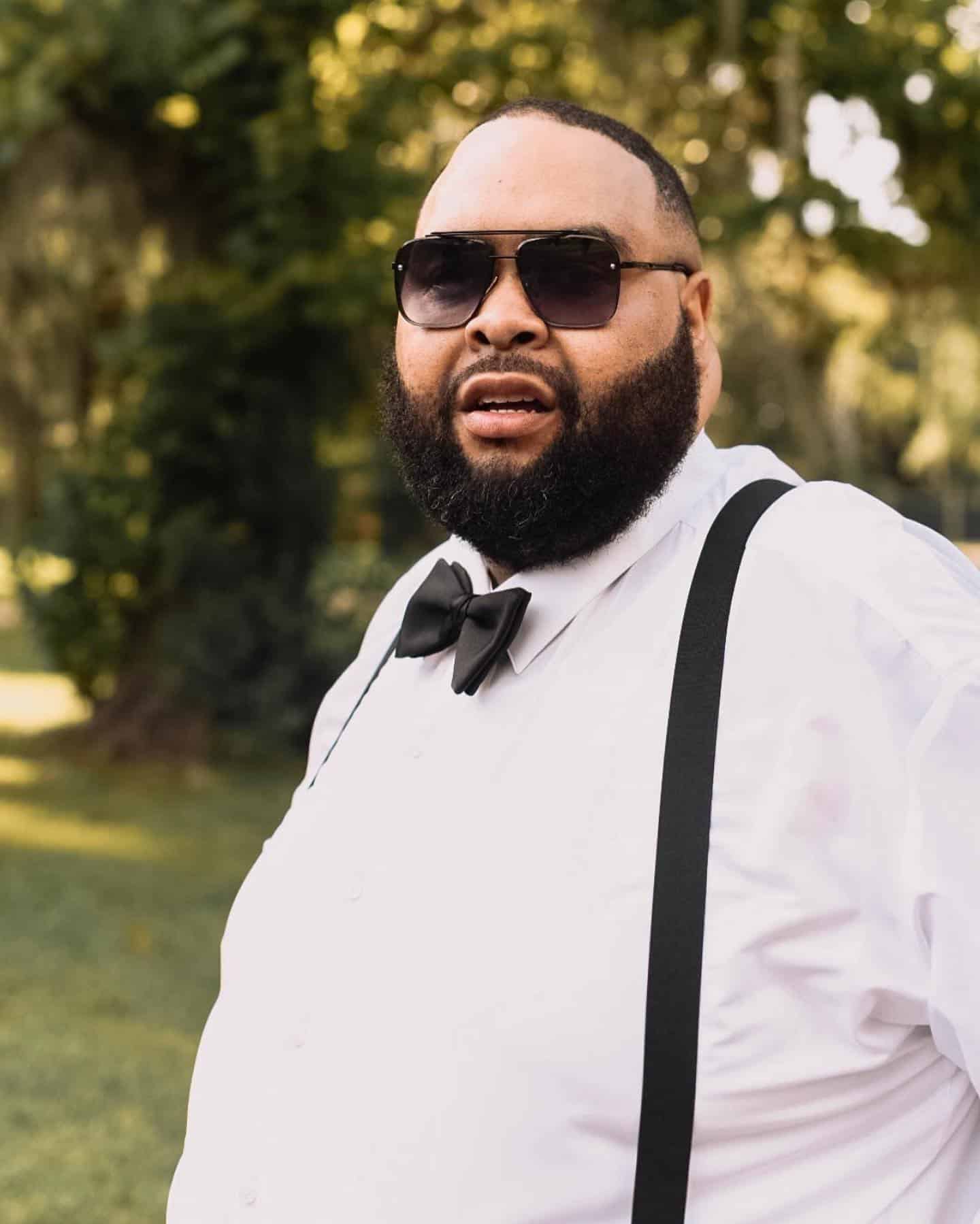 man wearing white shirt with bow tie and suspenders