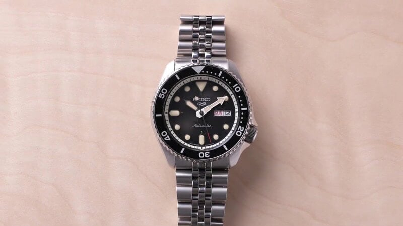 A seiko 5 watch with a jubilee bracelet