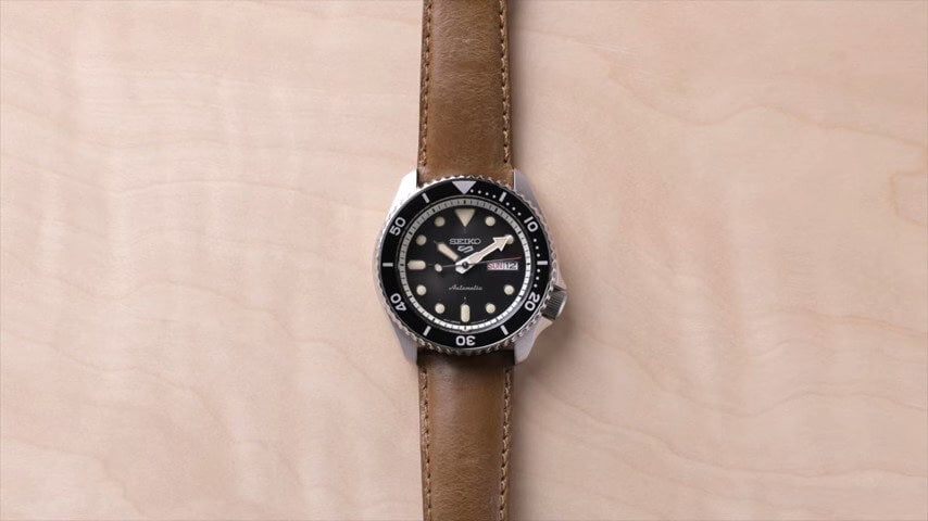 A seiko 5 watch with a lather straps