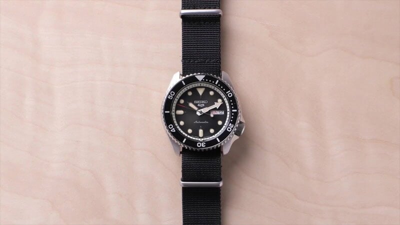 A seiko 5 watch with black NATO strap