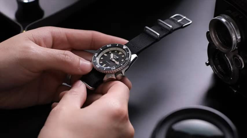 Holding a Seiko 5 watch with the NATO straps