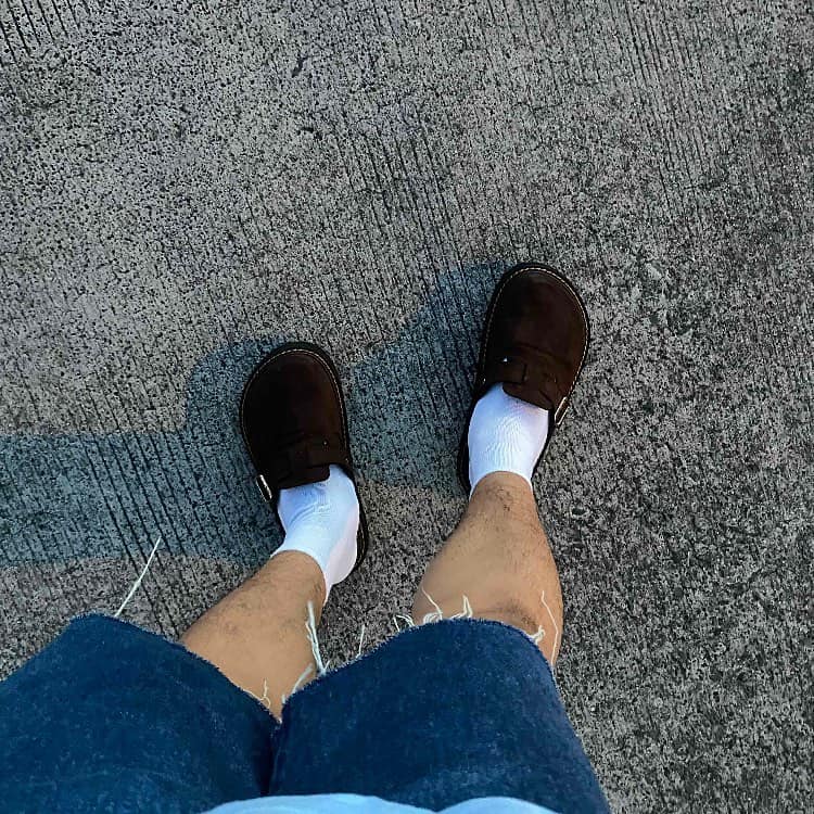man wearing a pair of brown clogs