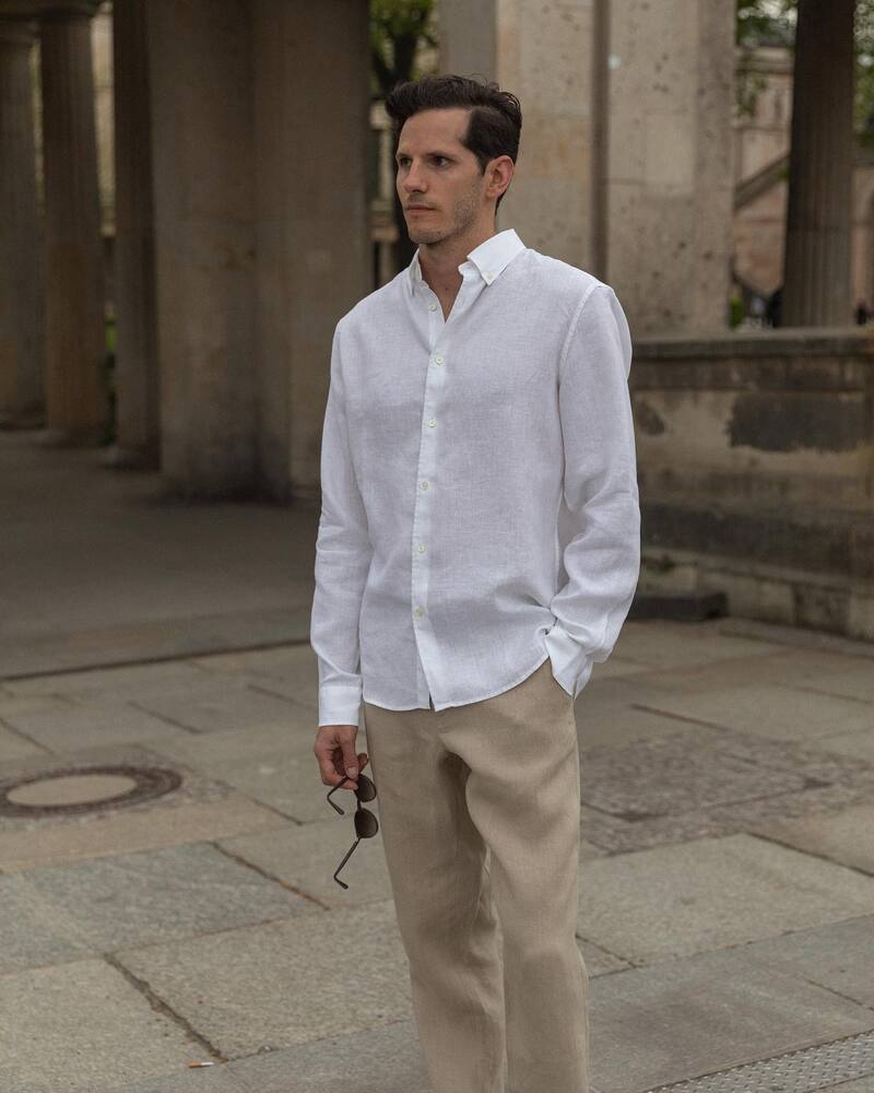 man wearing a white linen shirt and khaki pants