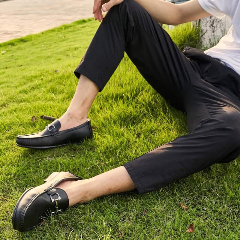 man sitting on the grass wearing a pair of bruno marc loafers