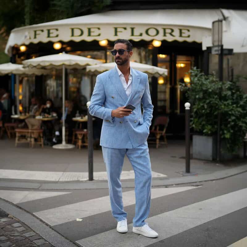 man wearing a blue suit and white sneakers by bruno marc