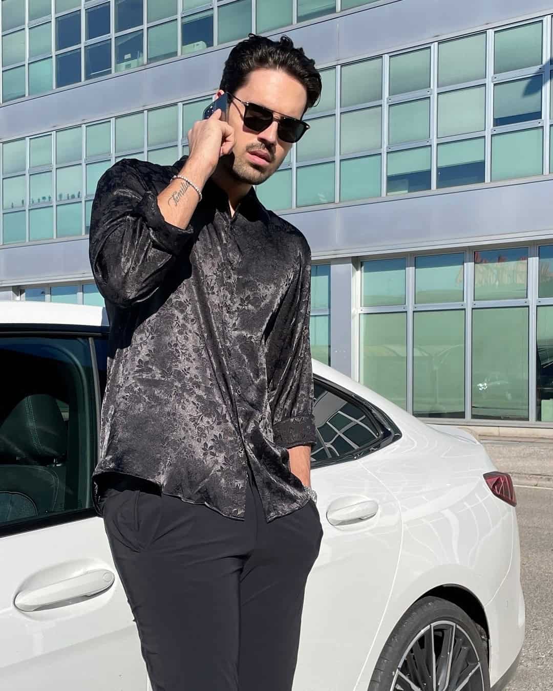 man on the phone wearing a black floral silk dress shirt by coofandy