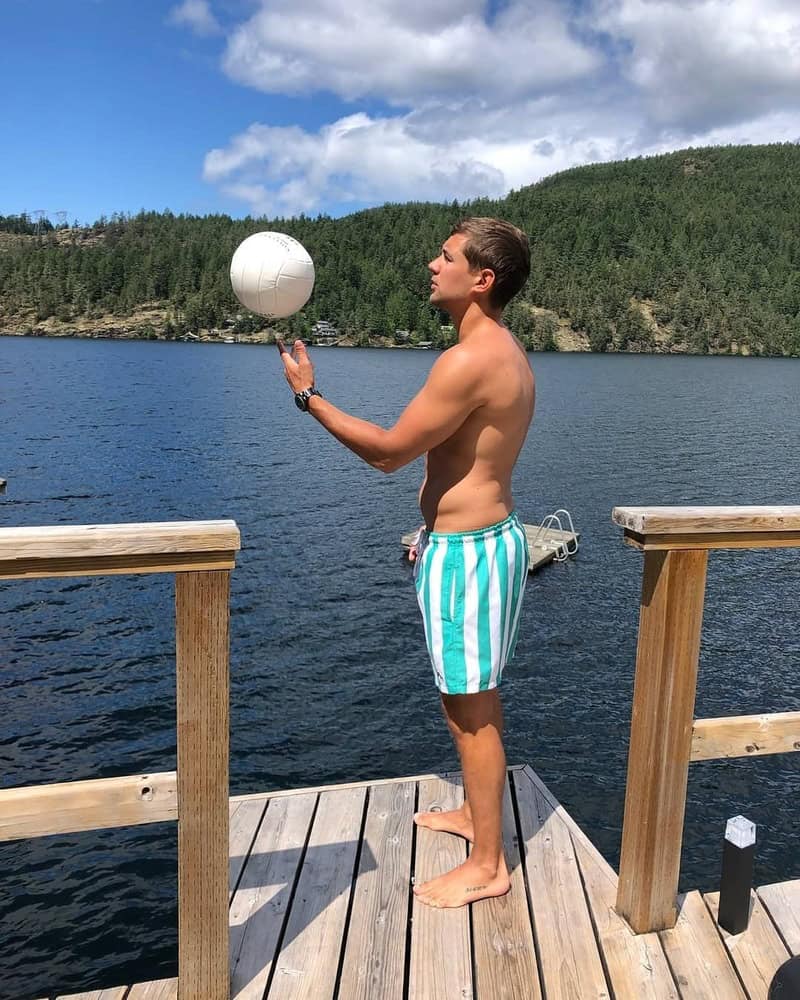 man wearing a striped shorts tossing a ball
