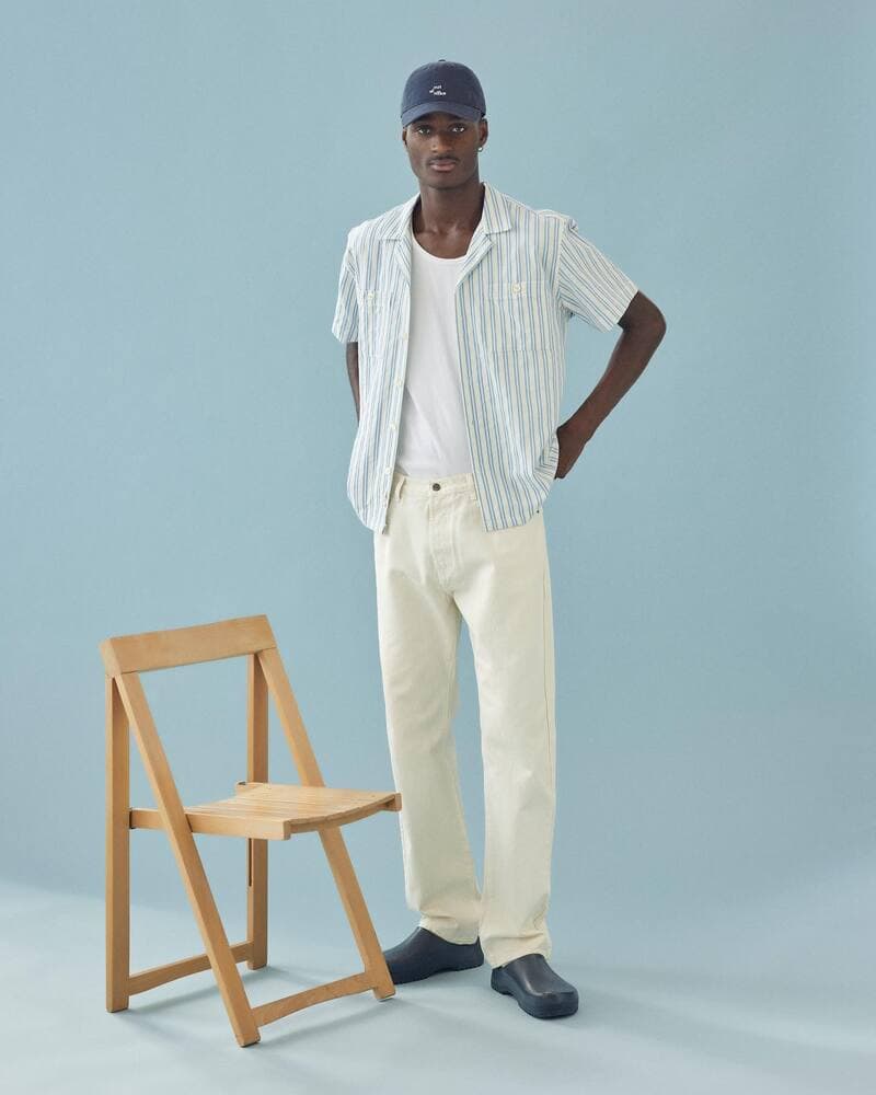 man wearing an unbuttoned short sleeved shirt and white jeans