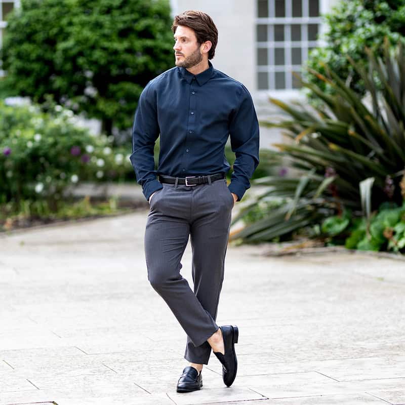 man wearing a navy shirt and grey pants