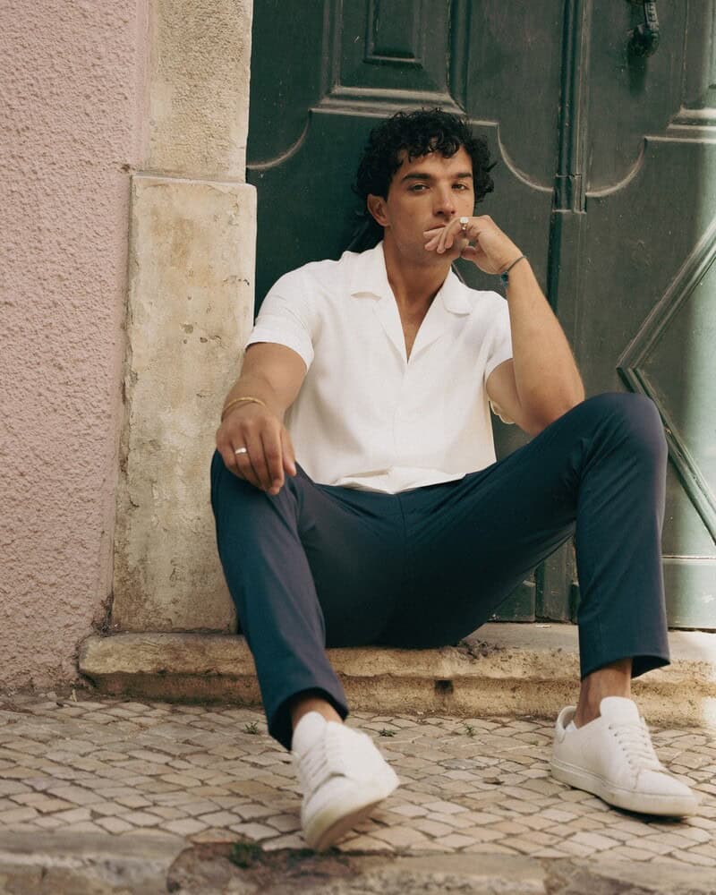 man sitting on a door step wearing the 24 trouser by l'estrange