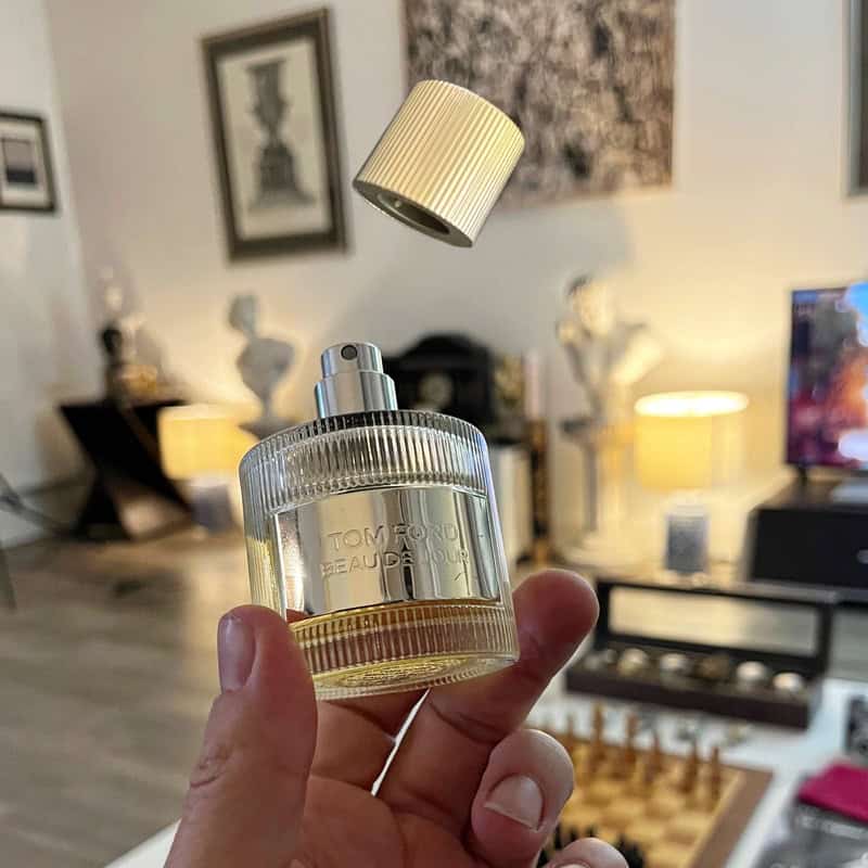 popping the bottle cap of a Beau De Jour cologne by Tom Ford