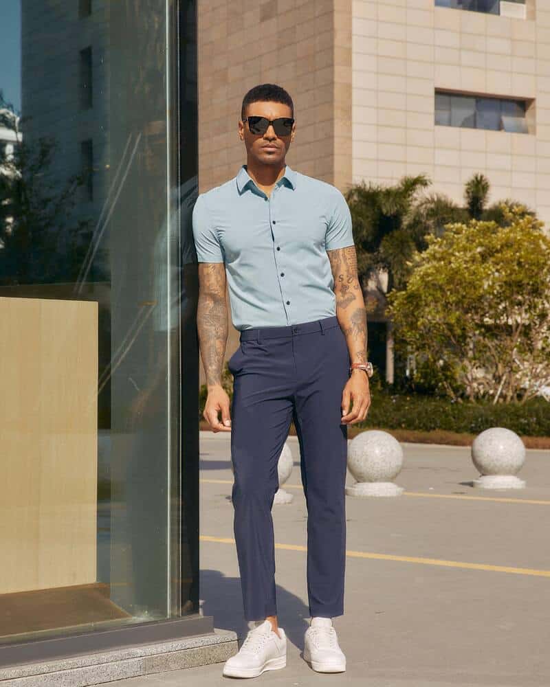 man wearing a blue short-sleeved shirt and grey cropped pants