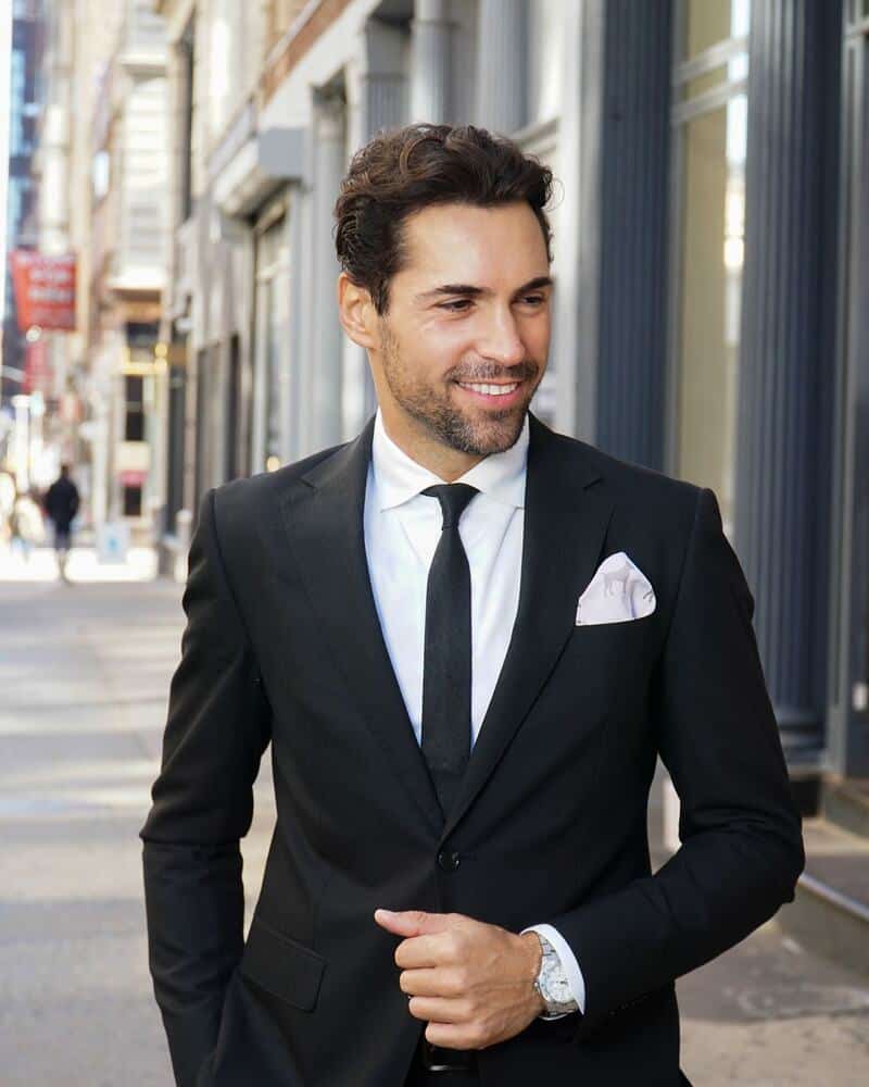 man in black suit with black tie and white pocket square