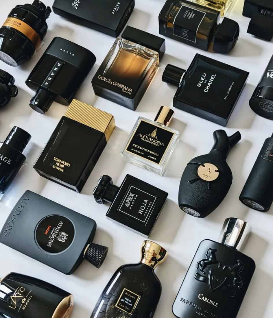 black and gold cologne bottles laid out on a white background aesthetically 