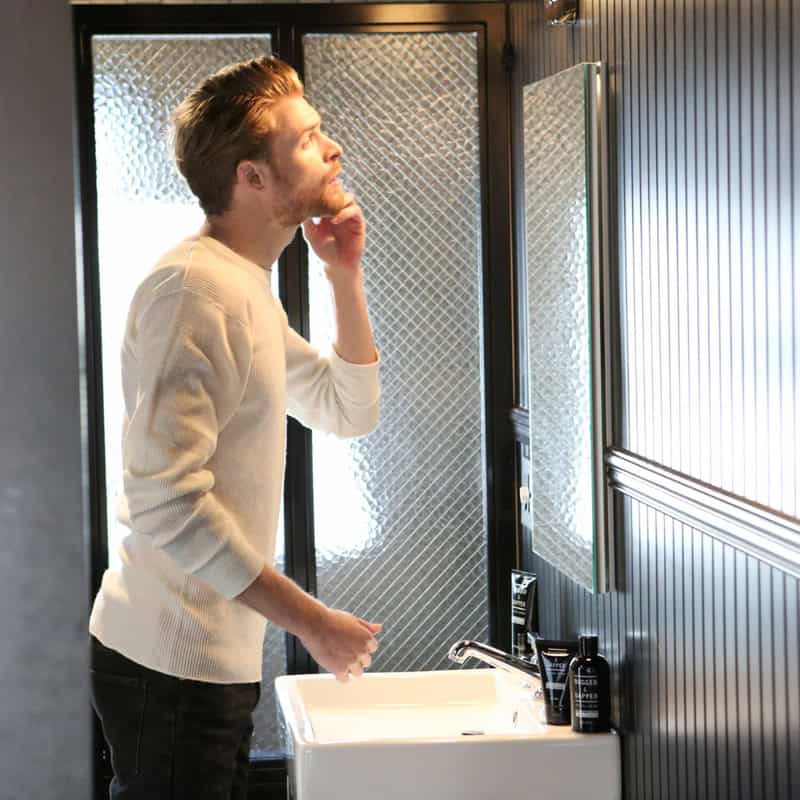 man checking face infront of a mirror