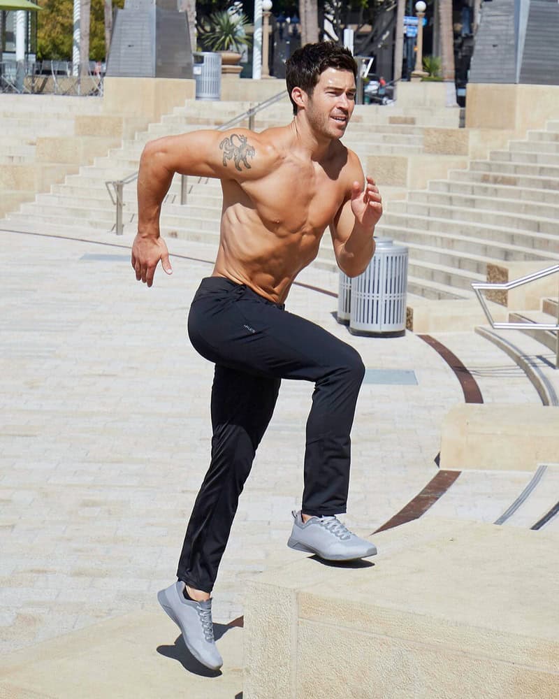 shirtless man running up the stairs