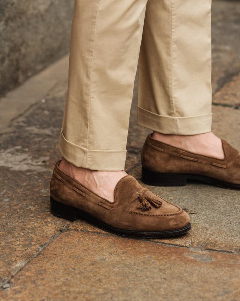 wearing a pair of suede loafers with tassels by velasca