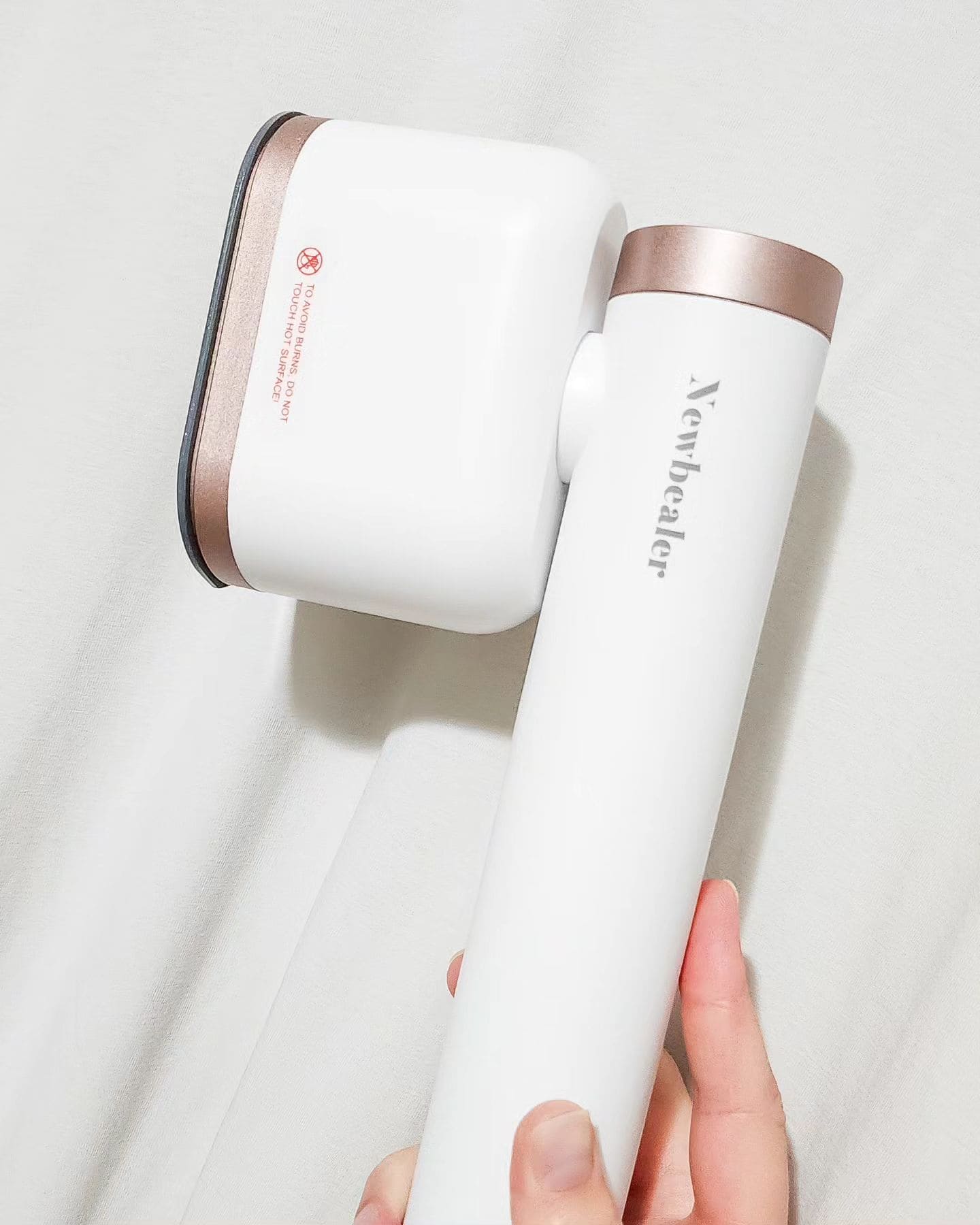 holding The Newbealer Handheld Steamer