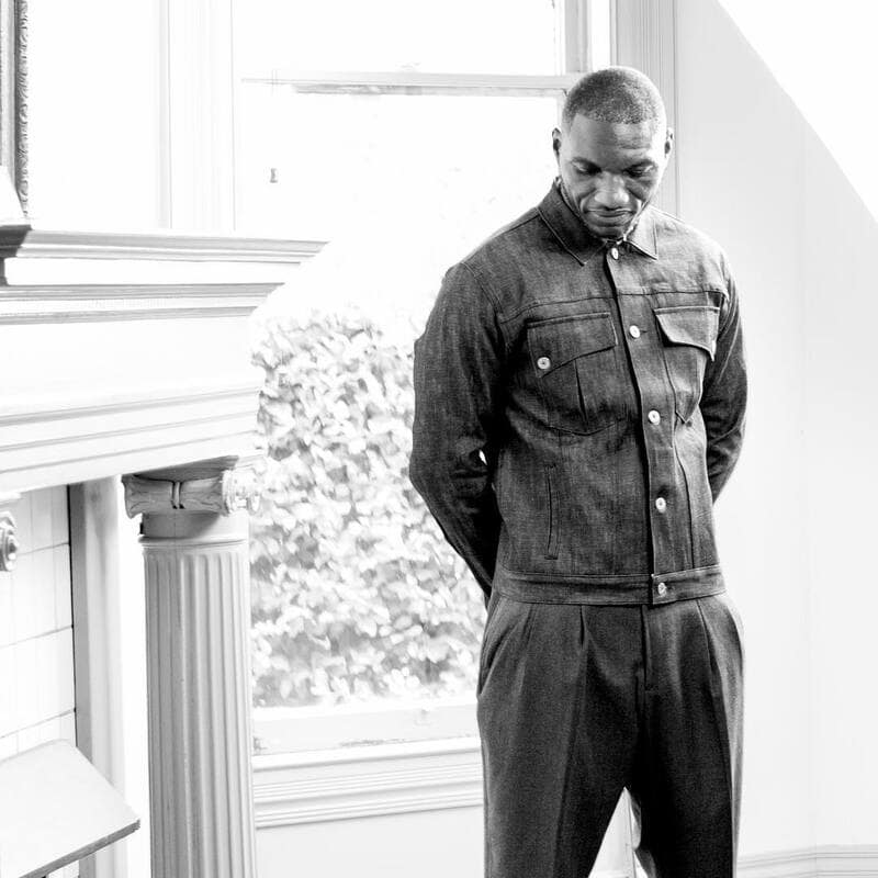 man wearing a denim shirt and pleated pants
