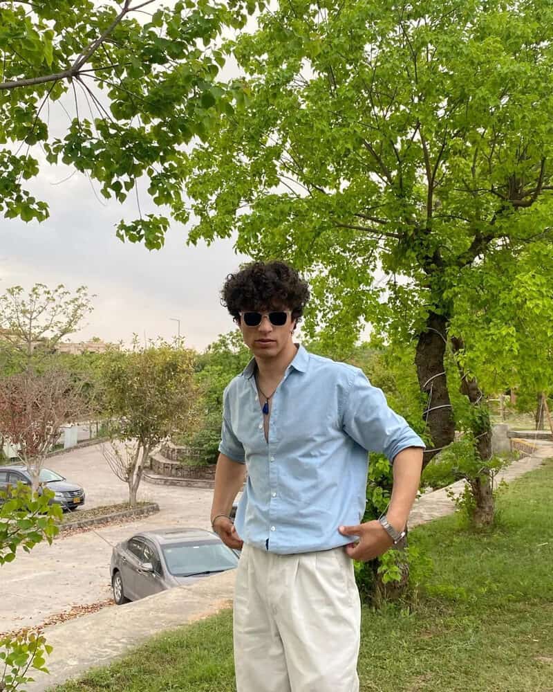 man wearing blue shirt and pleated khaki pants