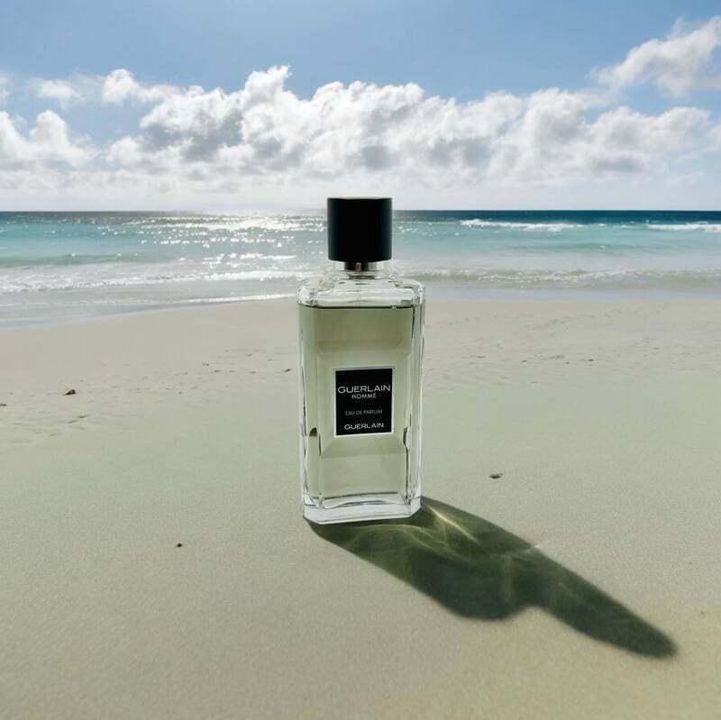 a bottle of guerlain homme eau de parfum at a beach