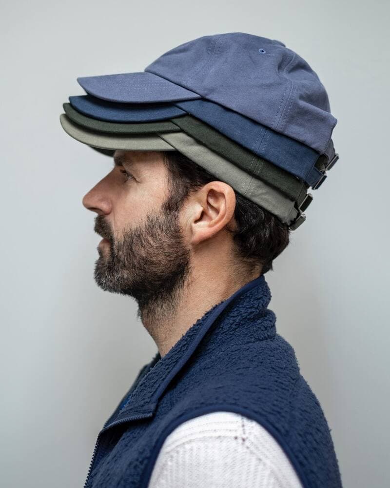 man wearing four layers of hats by isto