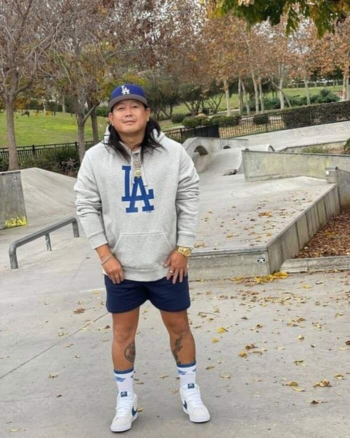 man in a cap wearing a hoodie and shorts