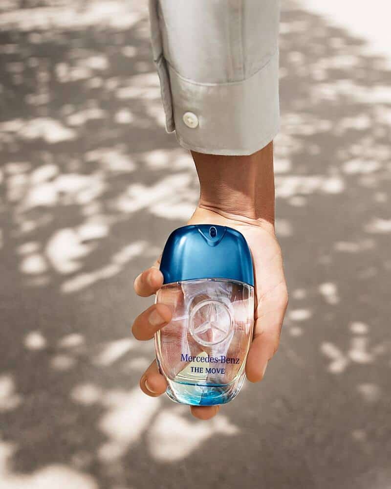 holding a bottle of the move cologne by mercedes benz