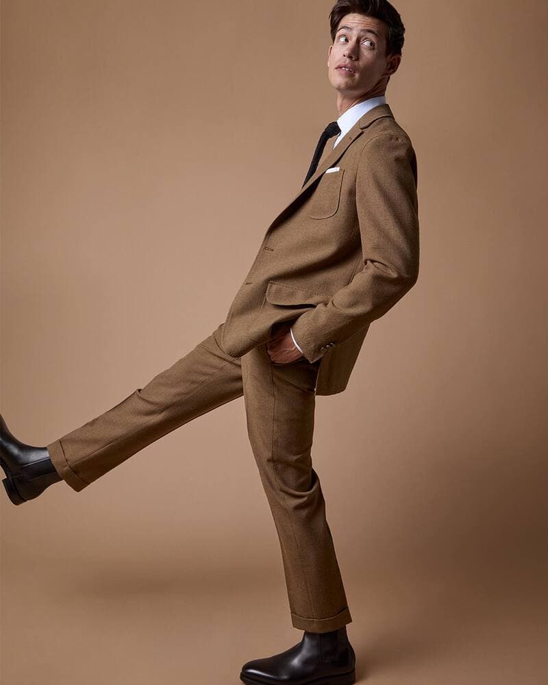 man in a brown suit and chelsea boots