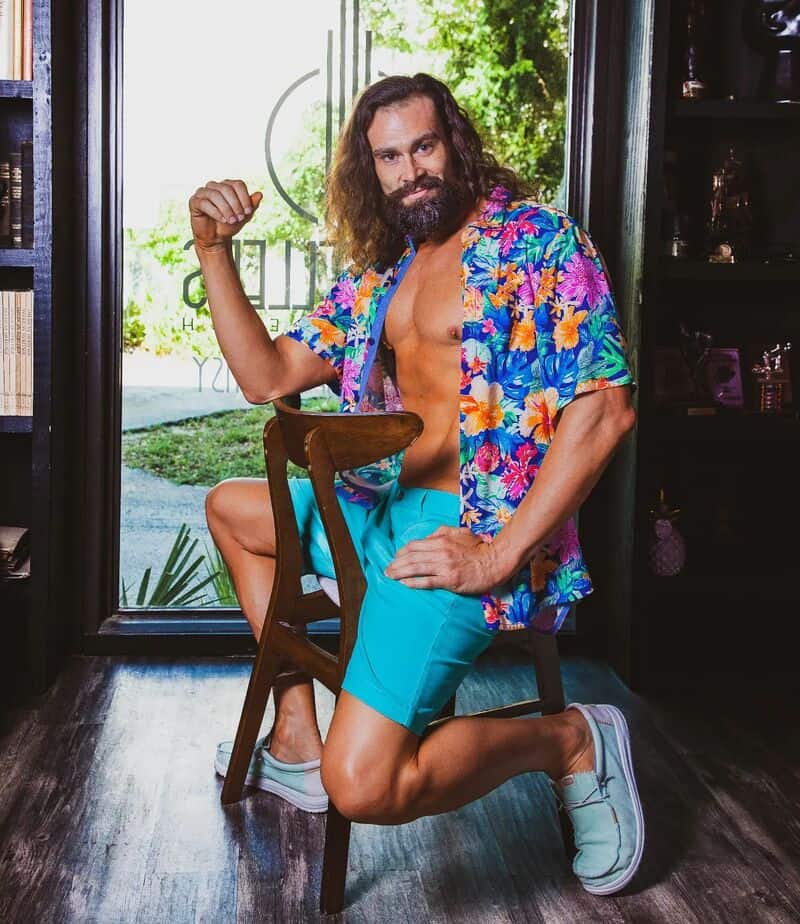 man in a colorful shirt sitting backwards on a chair