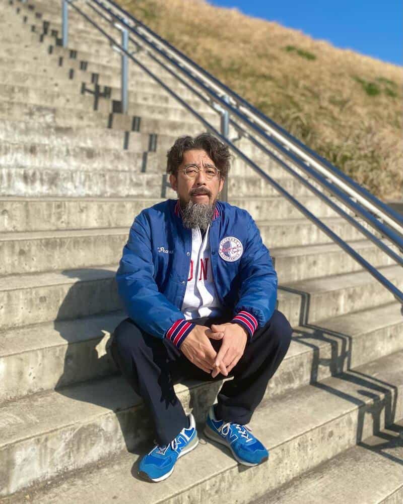 man in a blue light jacket sitting on the stairs