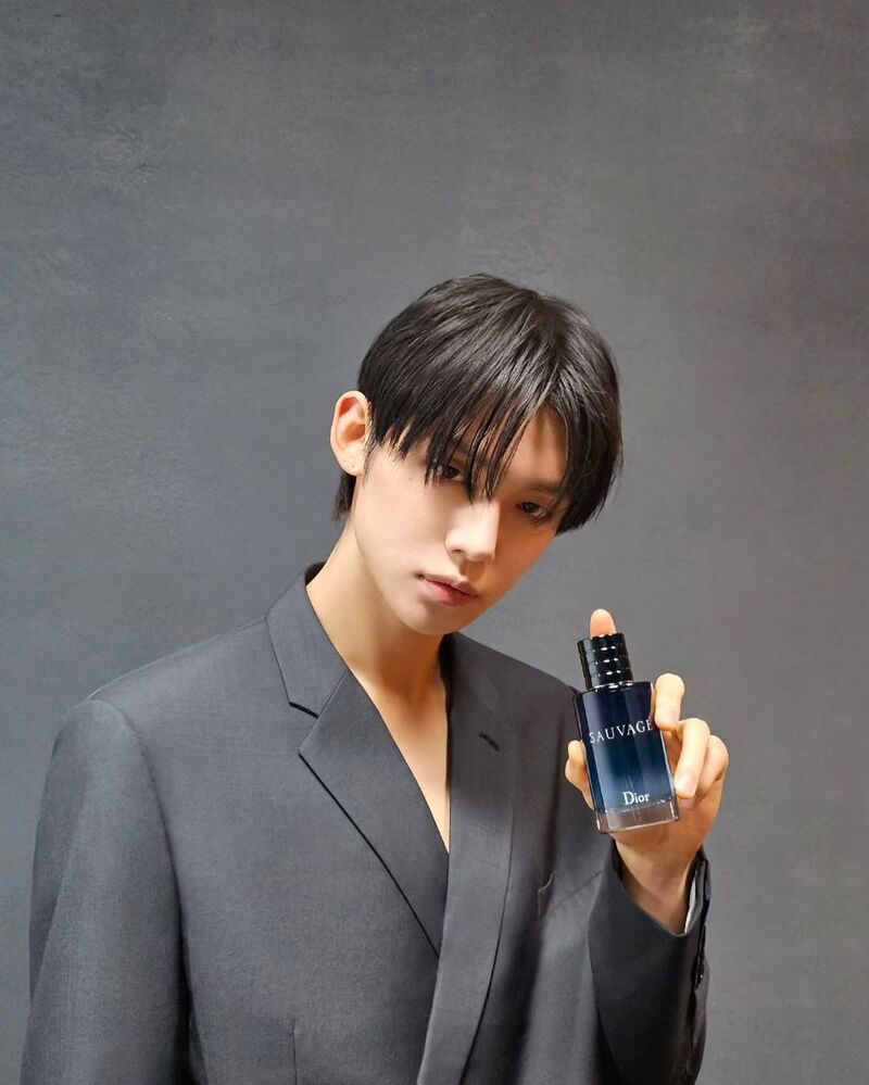 man holding a bottle of Dior Sauvage