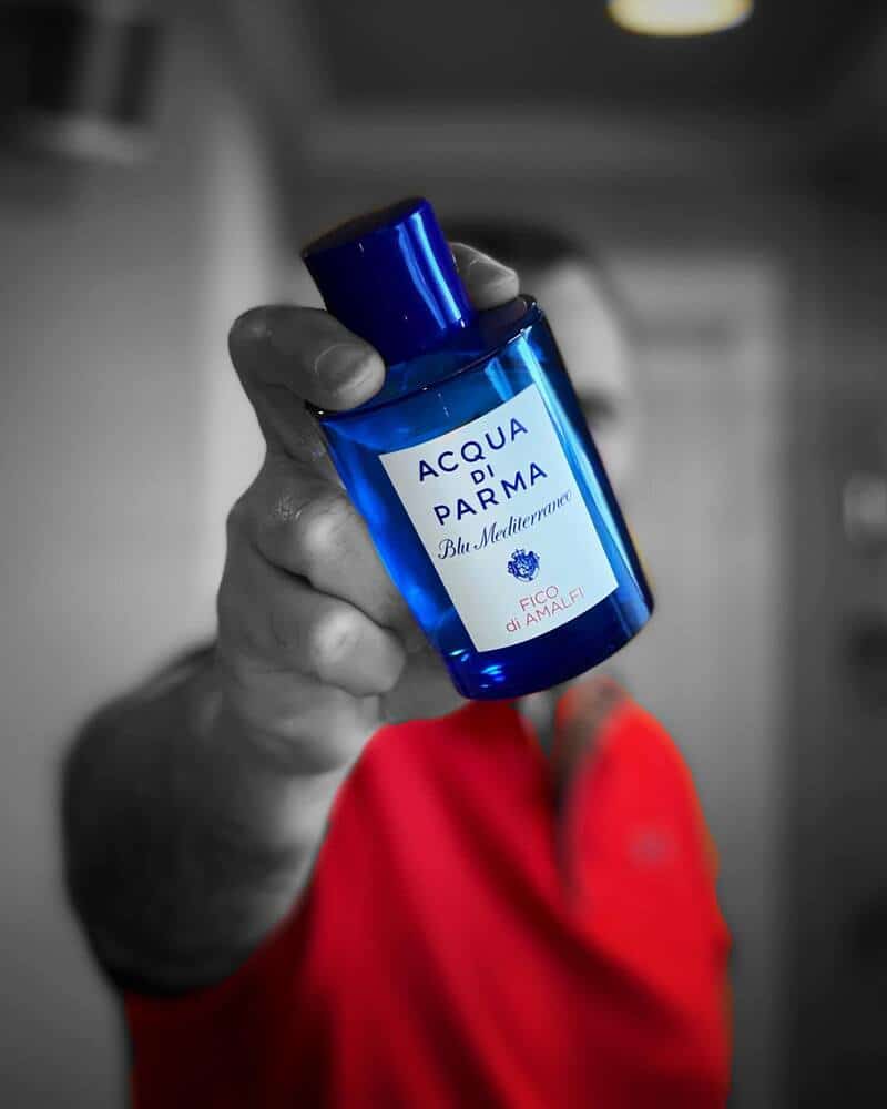 man holding a bottle of Acqua Di Parma Blu Mediterraneo Fico di Amalfi