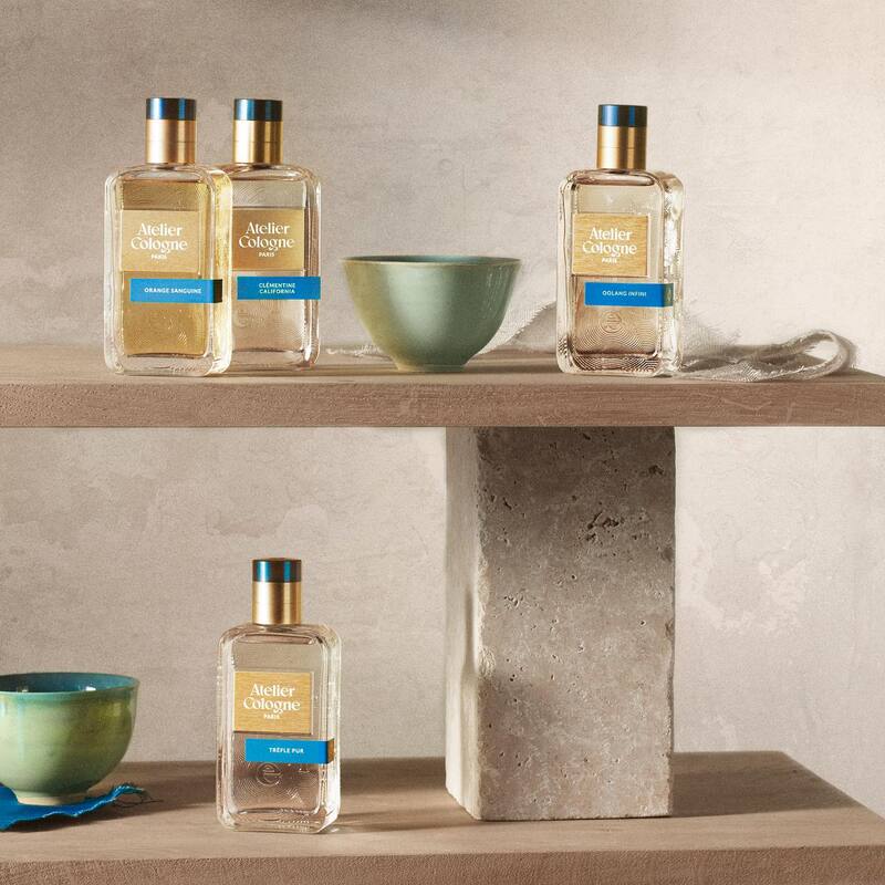 a collection of Ateller Colognes and two bowls on a shelf