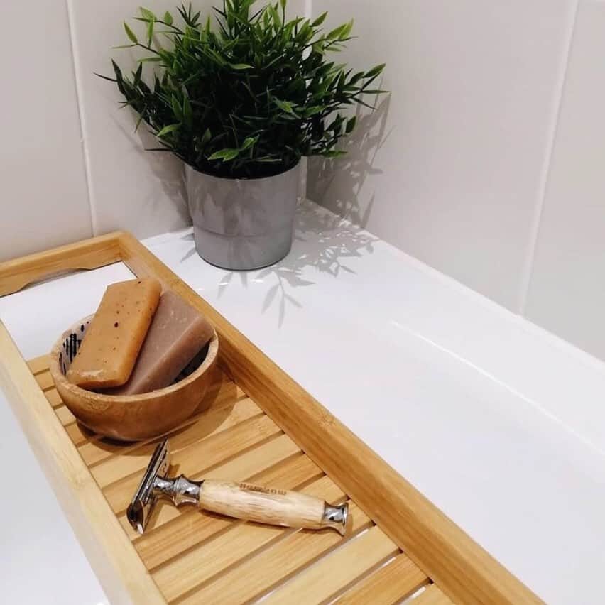 a Bamboo Safety Razor and Bar of Soaps on a bath tub tray
