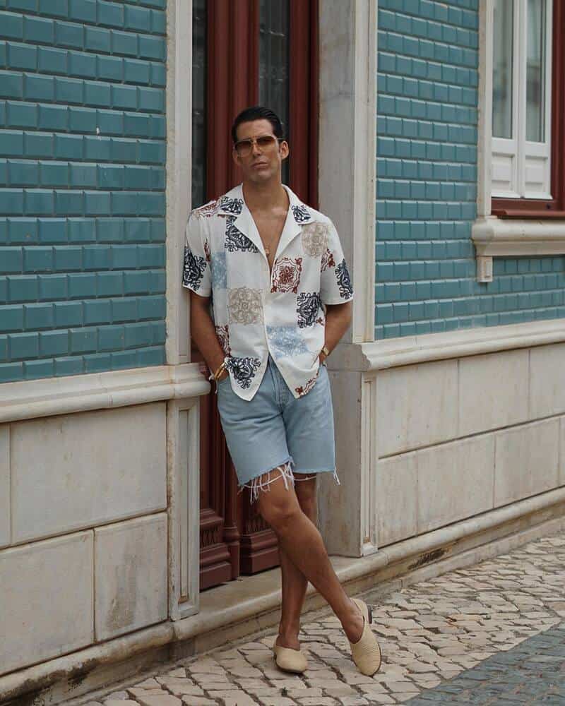 man wearing denim shorts leaning to a door jamb