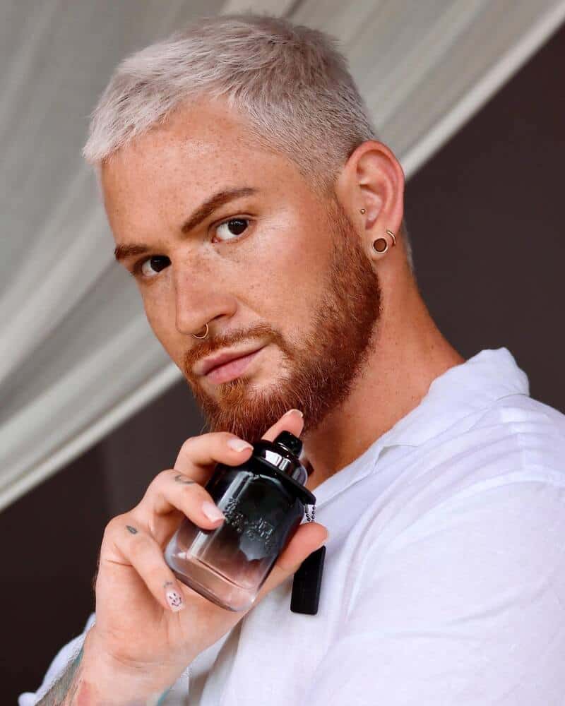 man holding a bottle of coach for men cologne