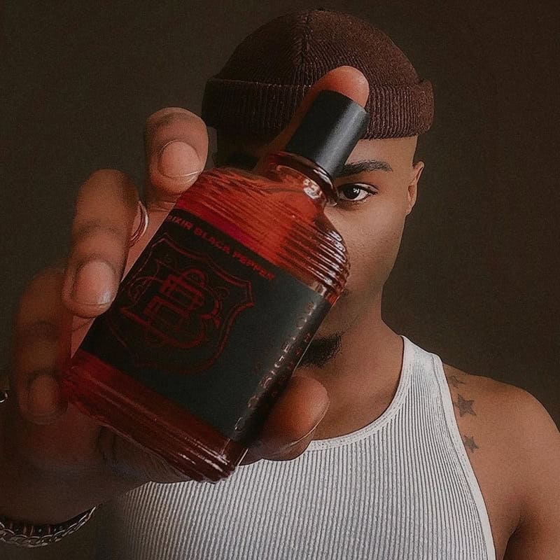 man with a beanie holding a bottle of C.O. Bigelow Black Pepper Cologne