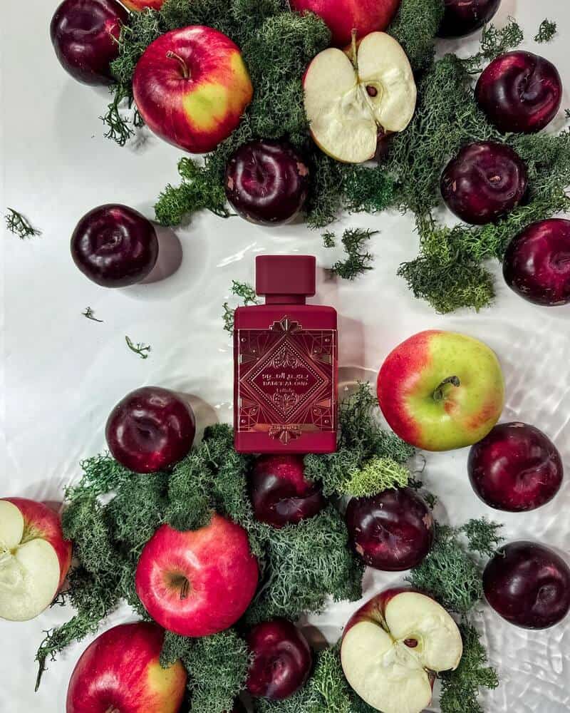 a bottle of Lattafa Bade'e Al oud Sublime surrounded by apples