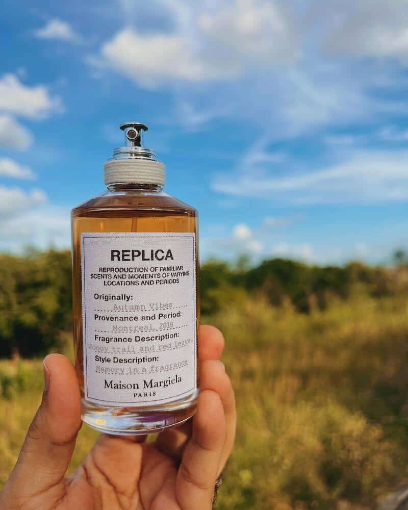 holding a bottle of autumn vibes cologne by Maison Margiela Replica