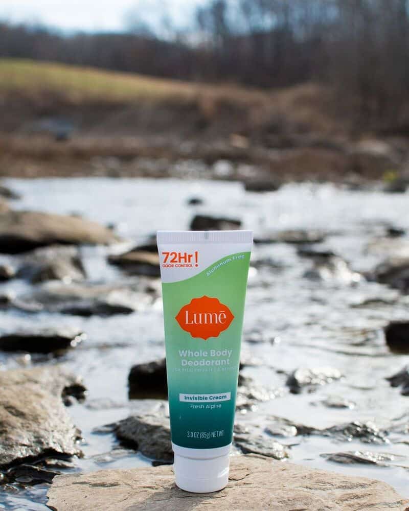 A Lume Deodorant on top of rock with flowing river in the background