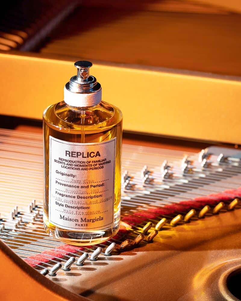 a bottle of jazz club cologne on top of the piano strings