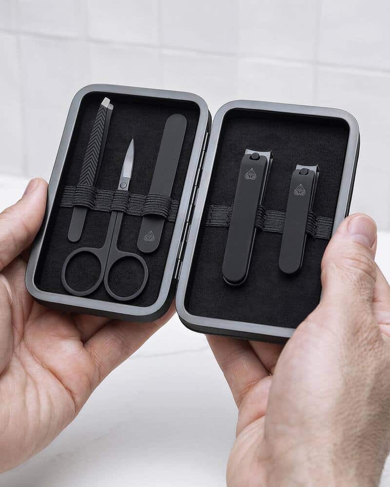 A man holding the Manscaped 5-Piece Precision Mens Nail Gromming Travel Set