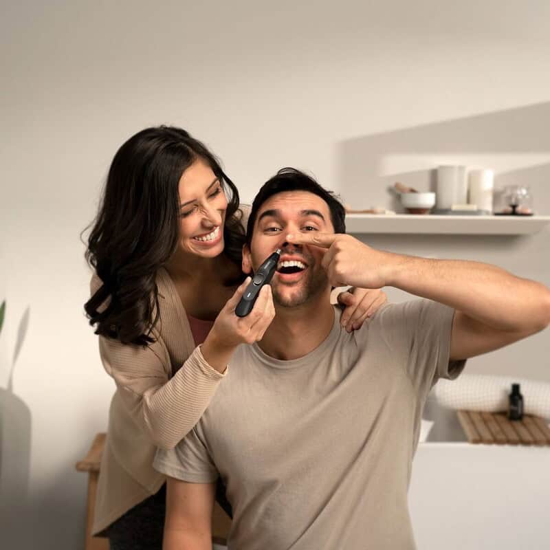 A woman trimming a man's nose hair