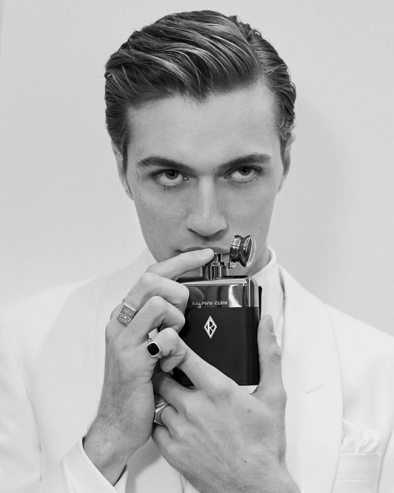 man smelling the bottle of a Ralph Club Parfum by Ralph Lauren