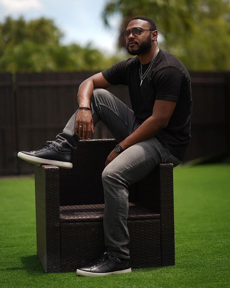 man sitting on a chair wearing a pair of rockport black sneakers
